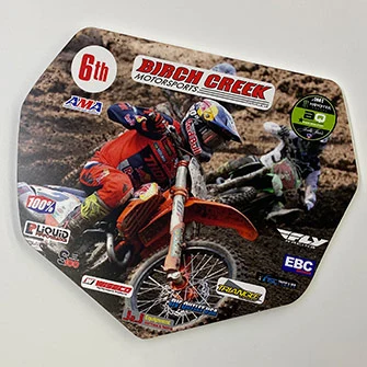 pvc-sign-of-dirt-bike-racer-on-a-wooded-trail-during-a-motorcross-race